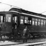 black and white conductors in front of a trolley car